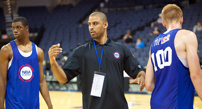 An image of a Top 100 Camp coach practicing with a camper.